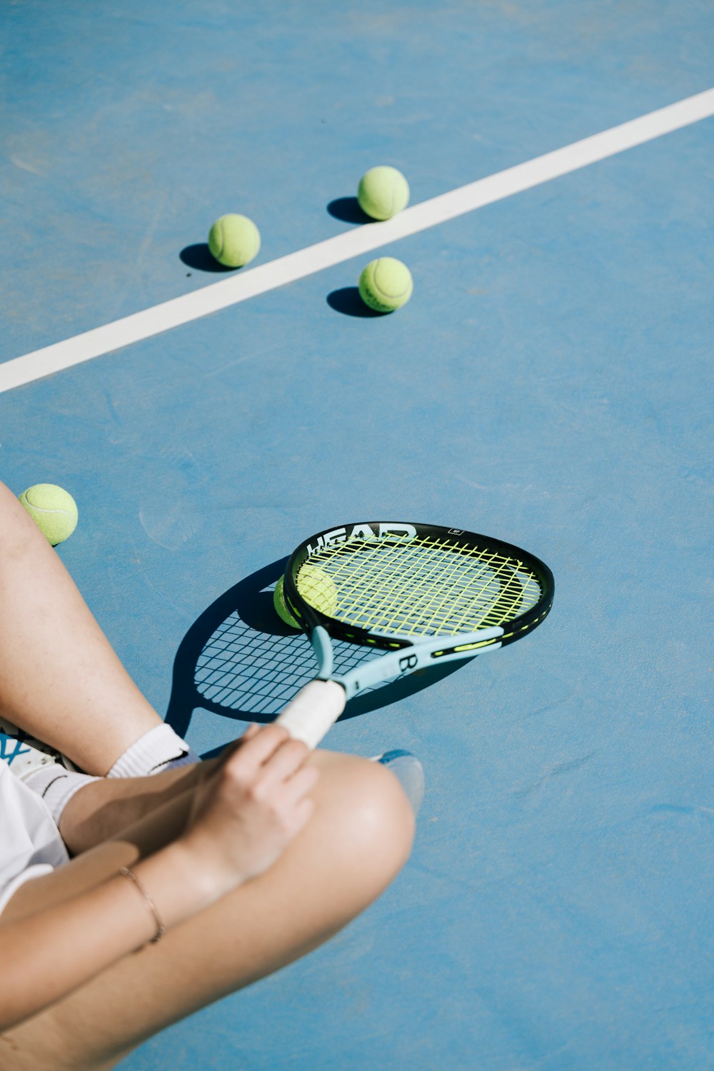 테니스 코트에 앉아 테니스 라켓을 들고 있는 여성