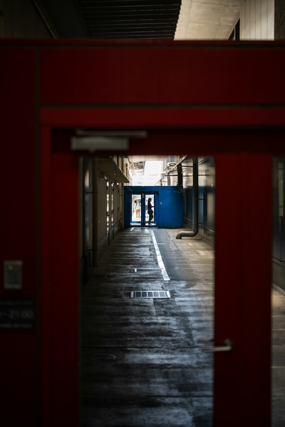 a train station with a red door and a person standing in the doorway