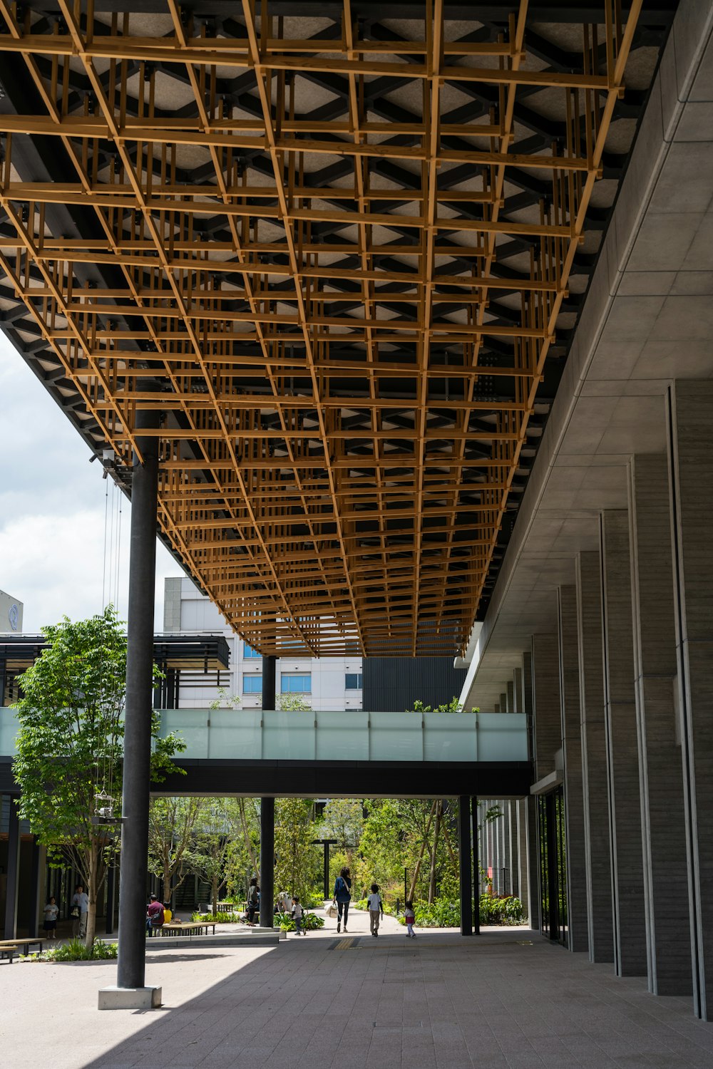 two people are walking under a large metal structure