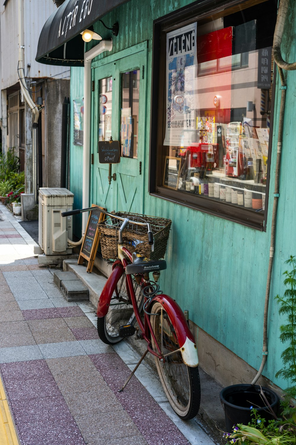 a red bike parked next to a green building