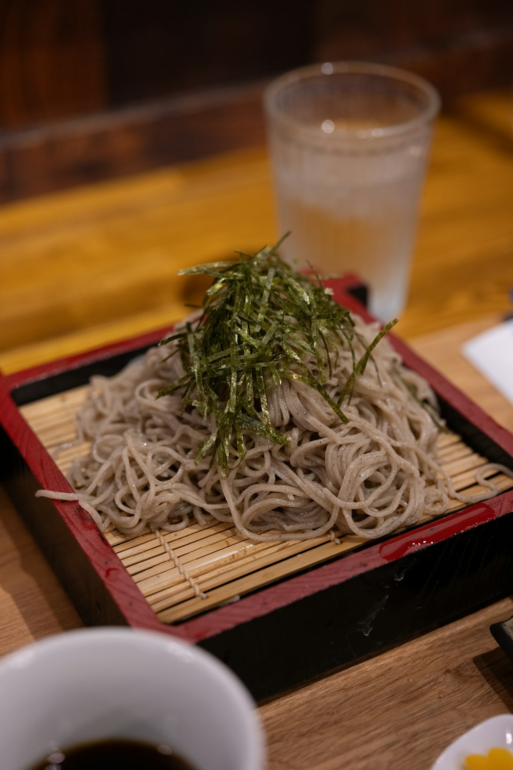 a plate of noodles and a cup of tea on a table