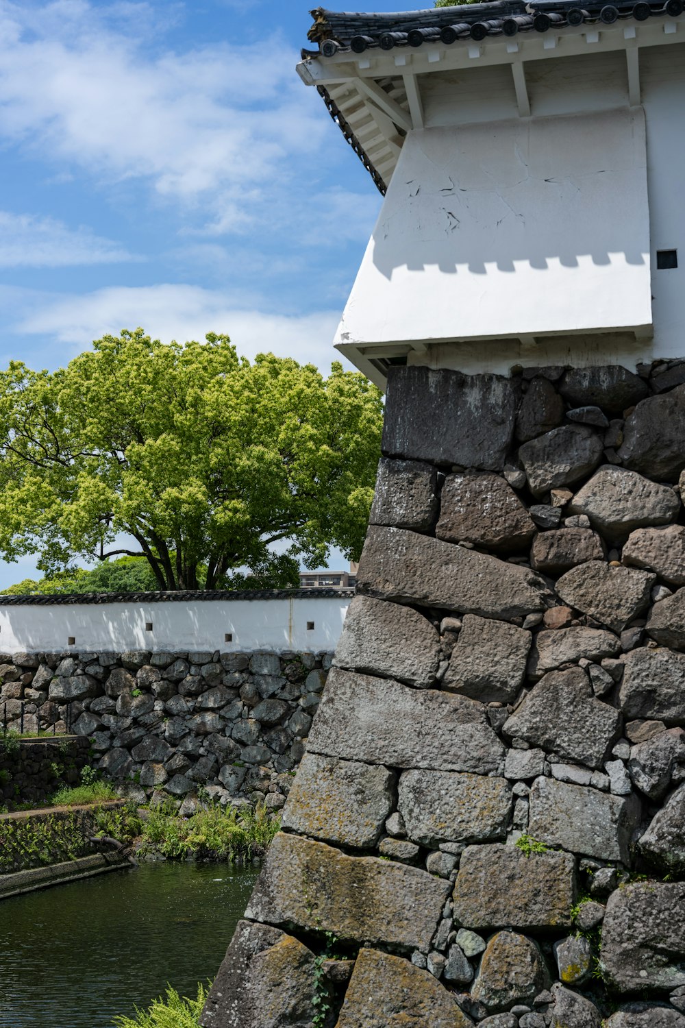 a stone wall next to a body of water