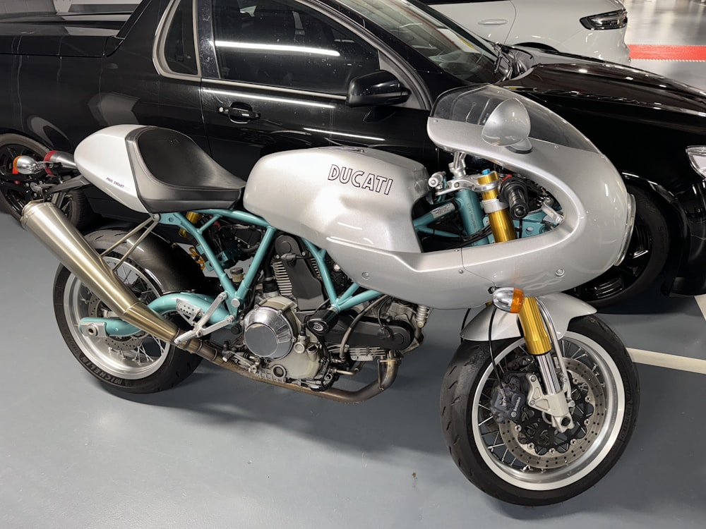 a motorcycle parked next to a car in a garage