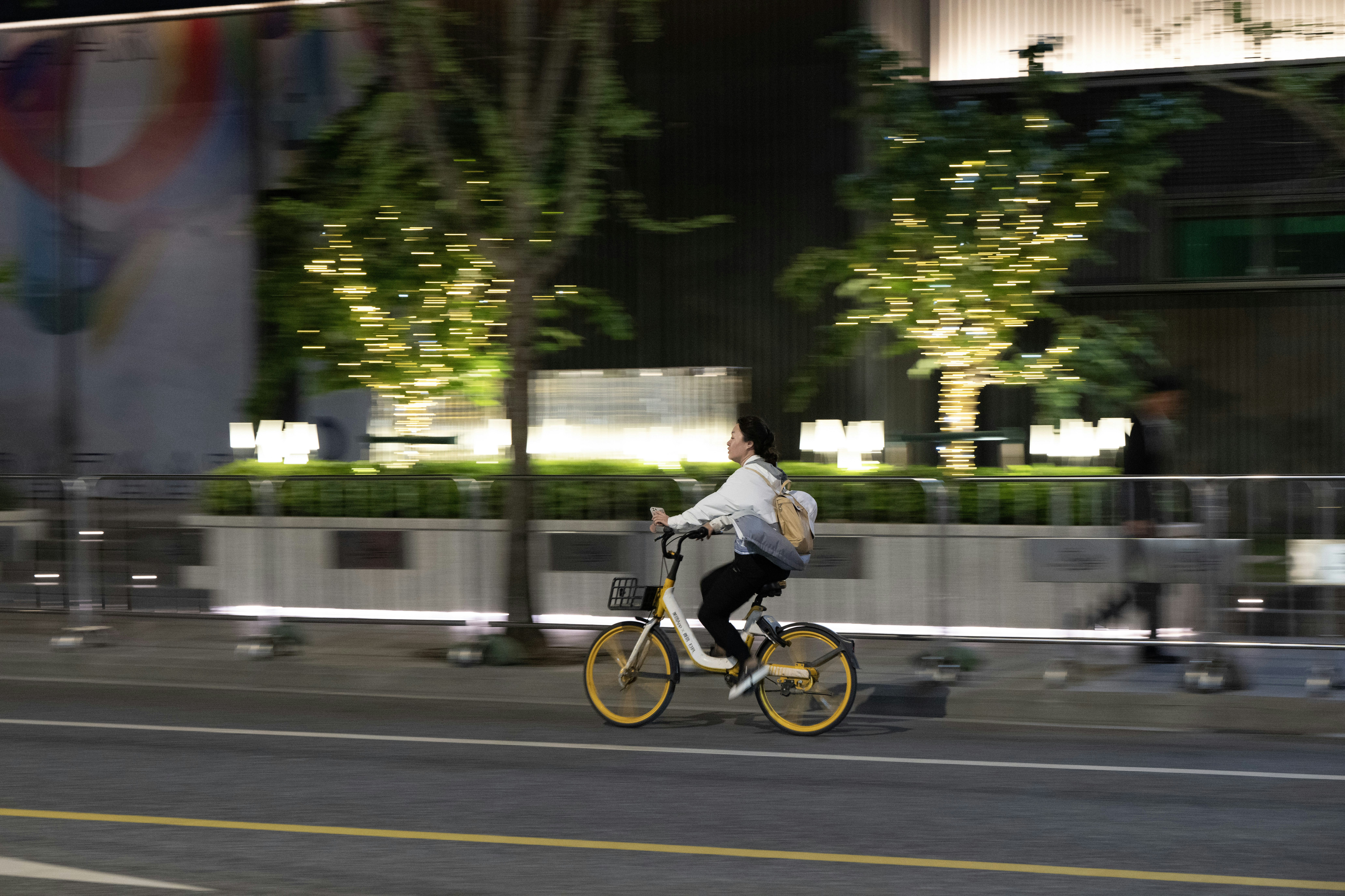 a man riding a bike down a street at night