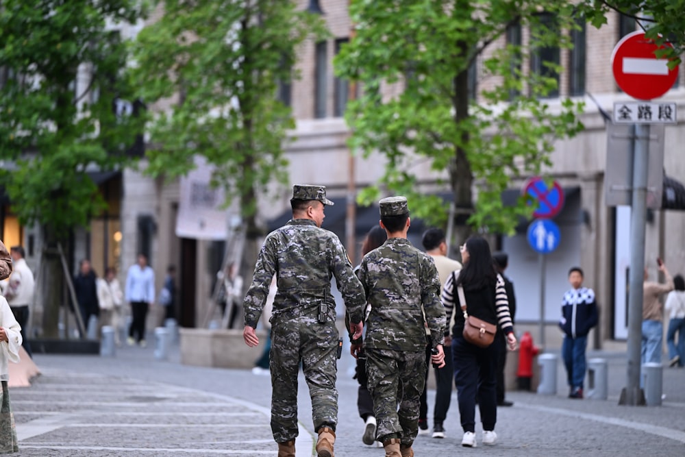 two soldiers walking down the street in a city