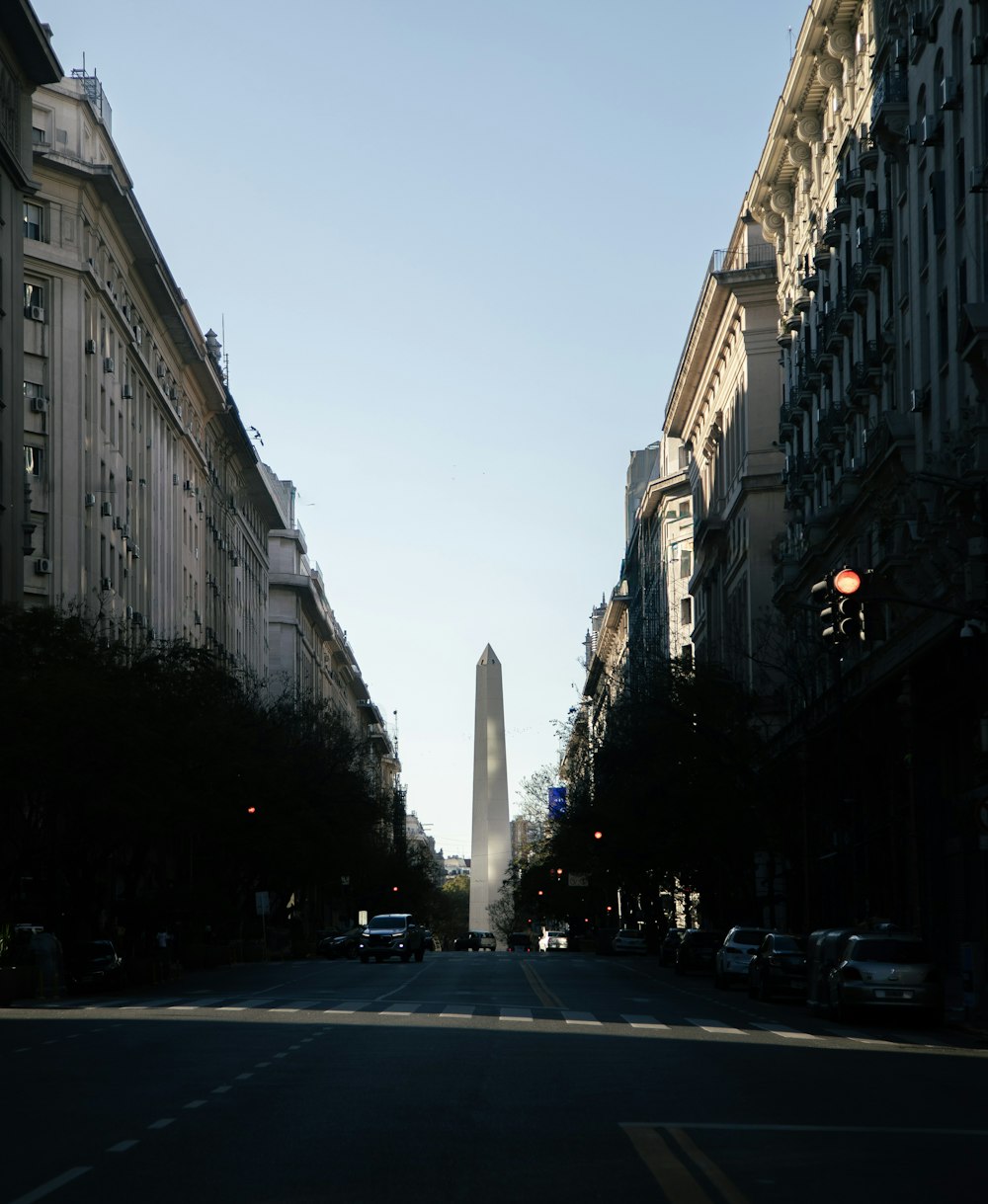 a city street with tall buildings and a tall obelisk