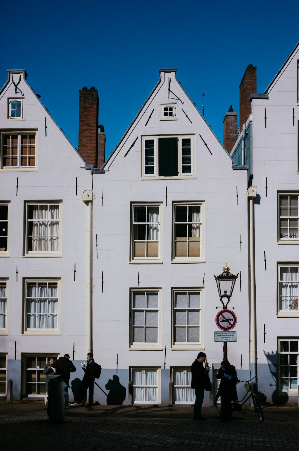 a group of people standing in front of a white building