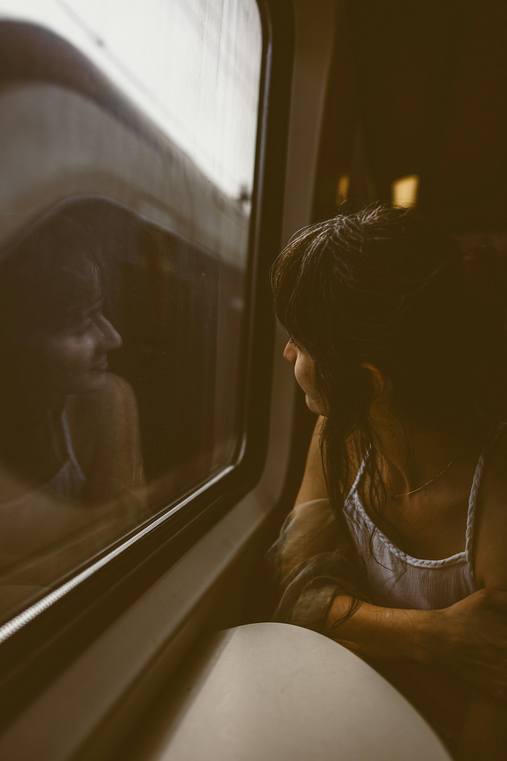 a woman sitting on a train looking out the window