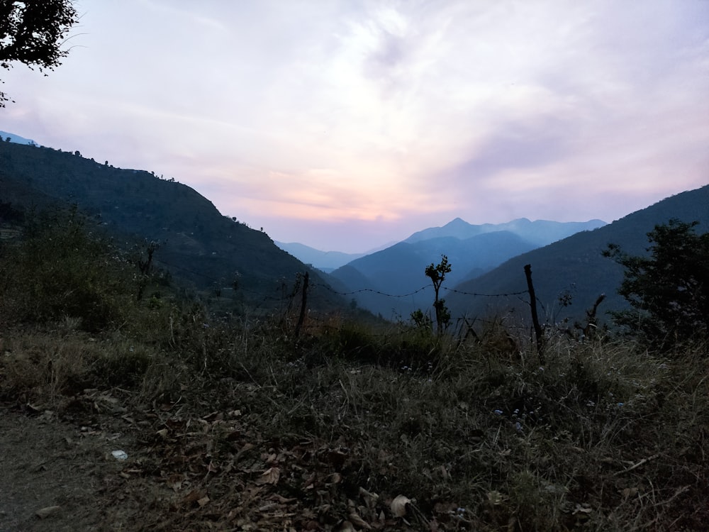 a view of a mountain with a fence in the foreground