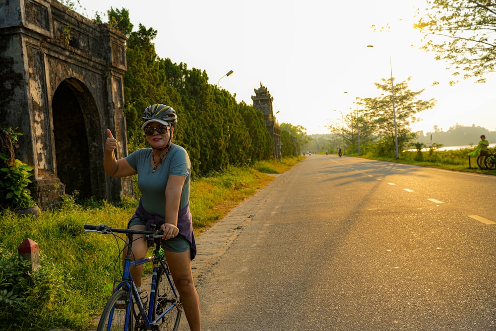 a woman riding a bike down a road