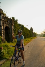 a woman riding a bike down a rural road