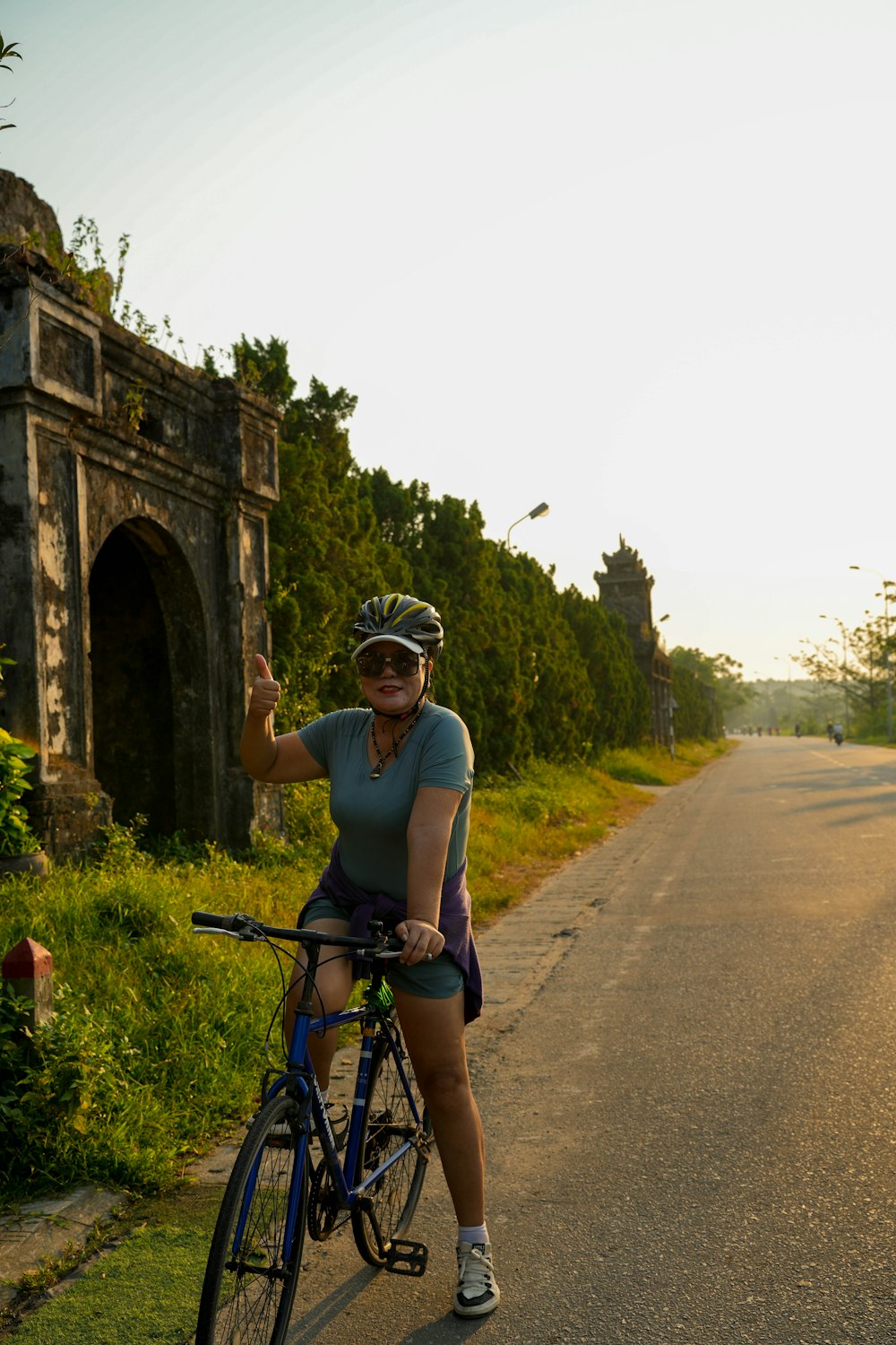 a woman riding a bike down a rural road