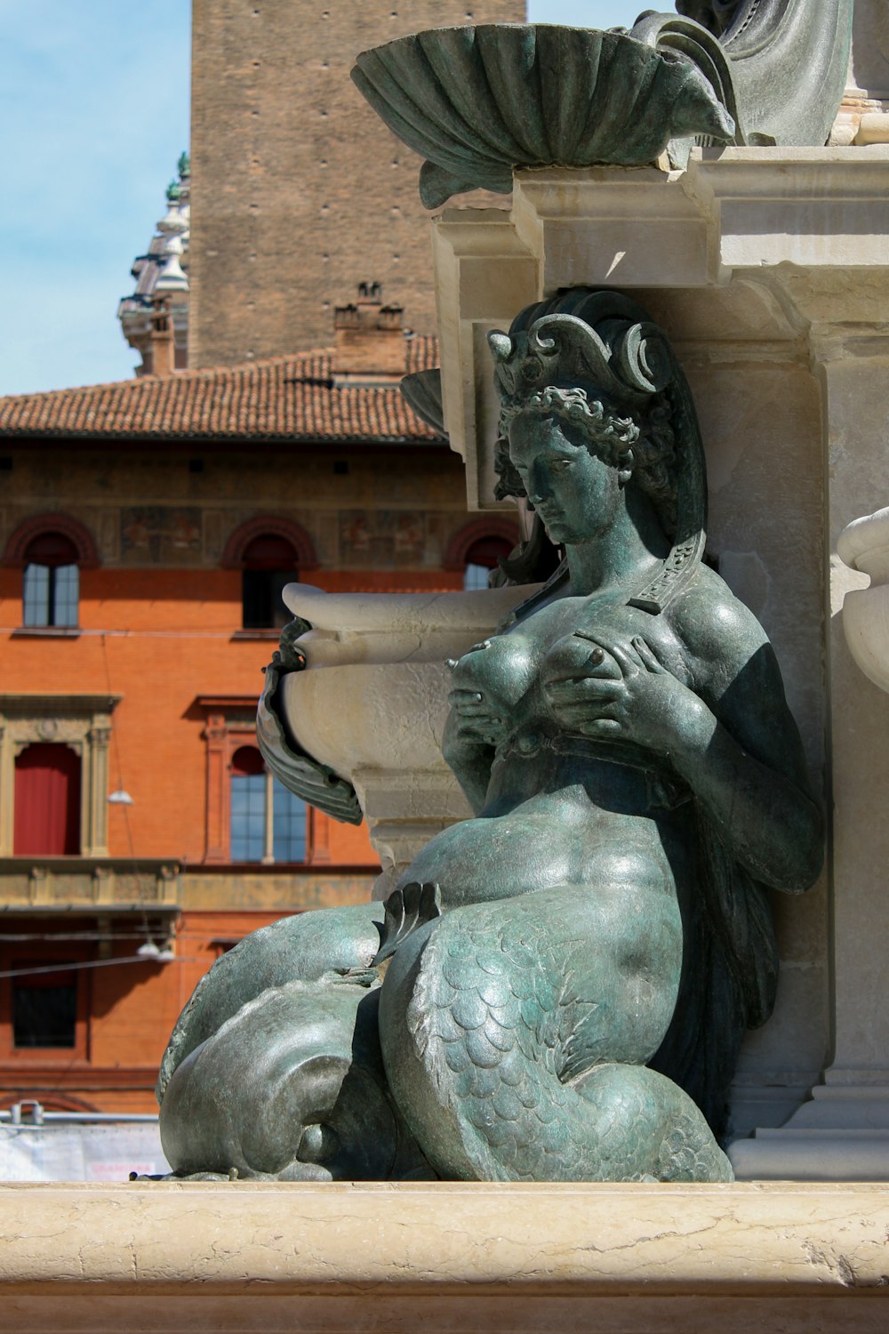 a statue of a woman holding a vase in front of a building