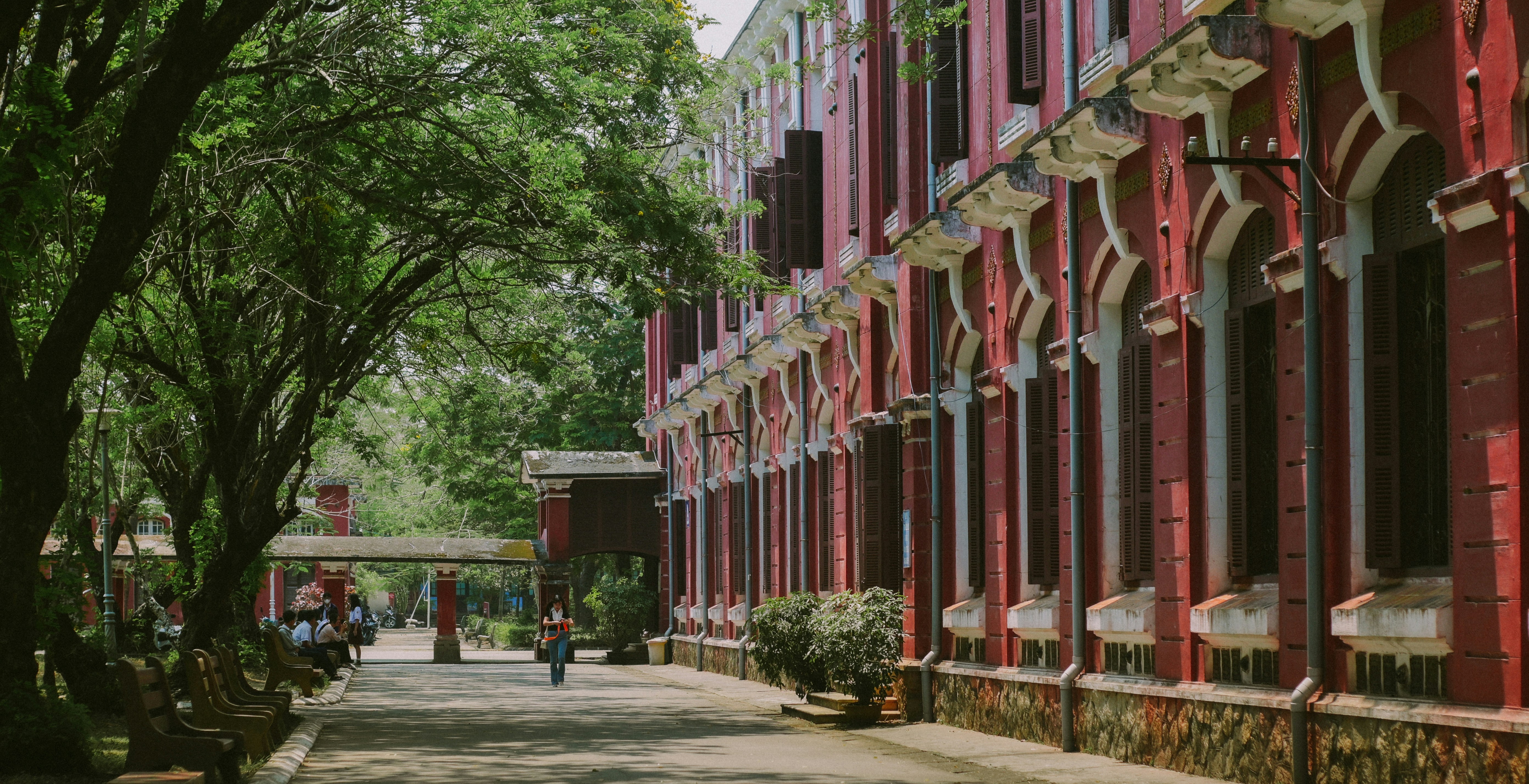 a person walking down a street next to a red building