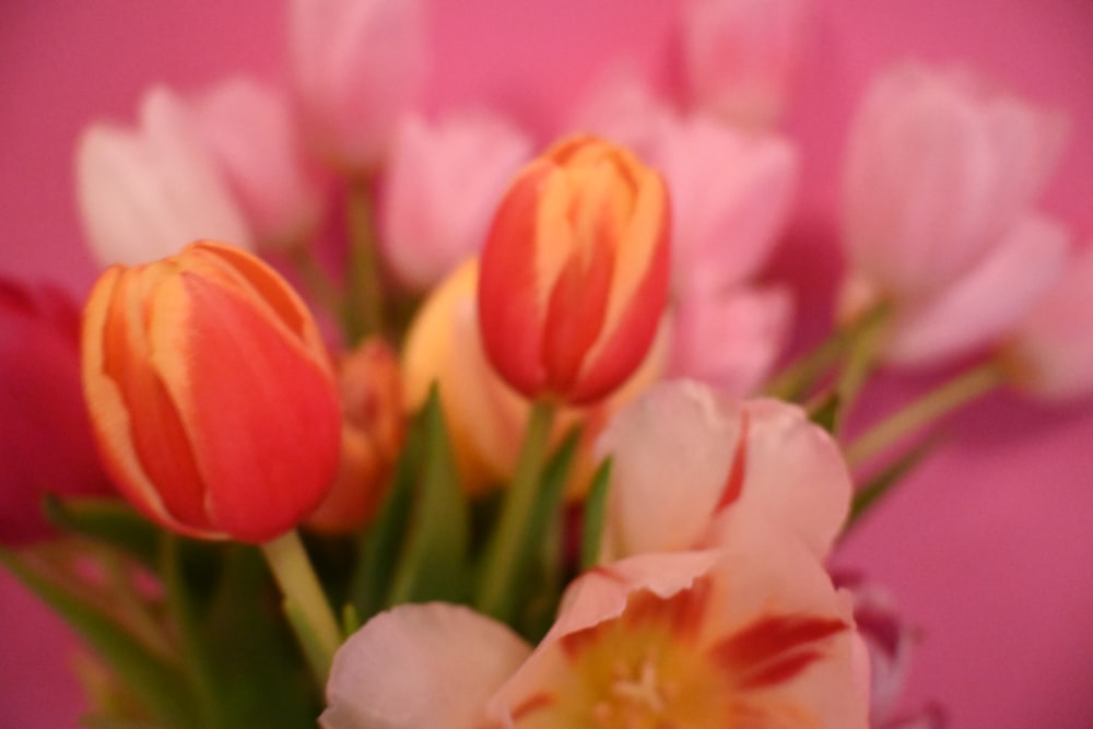 a vase filled with lots of pink and yellow flowers