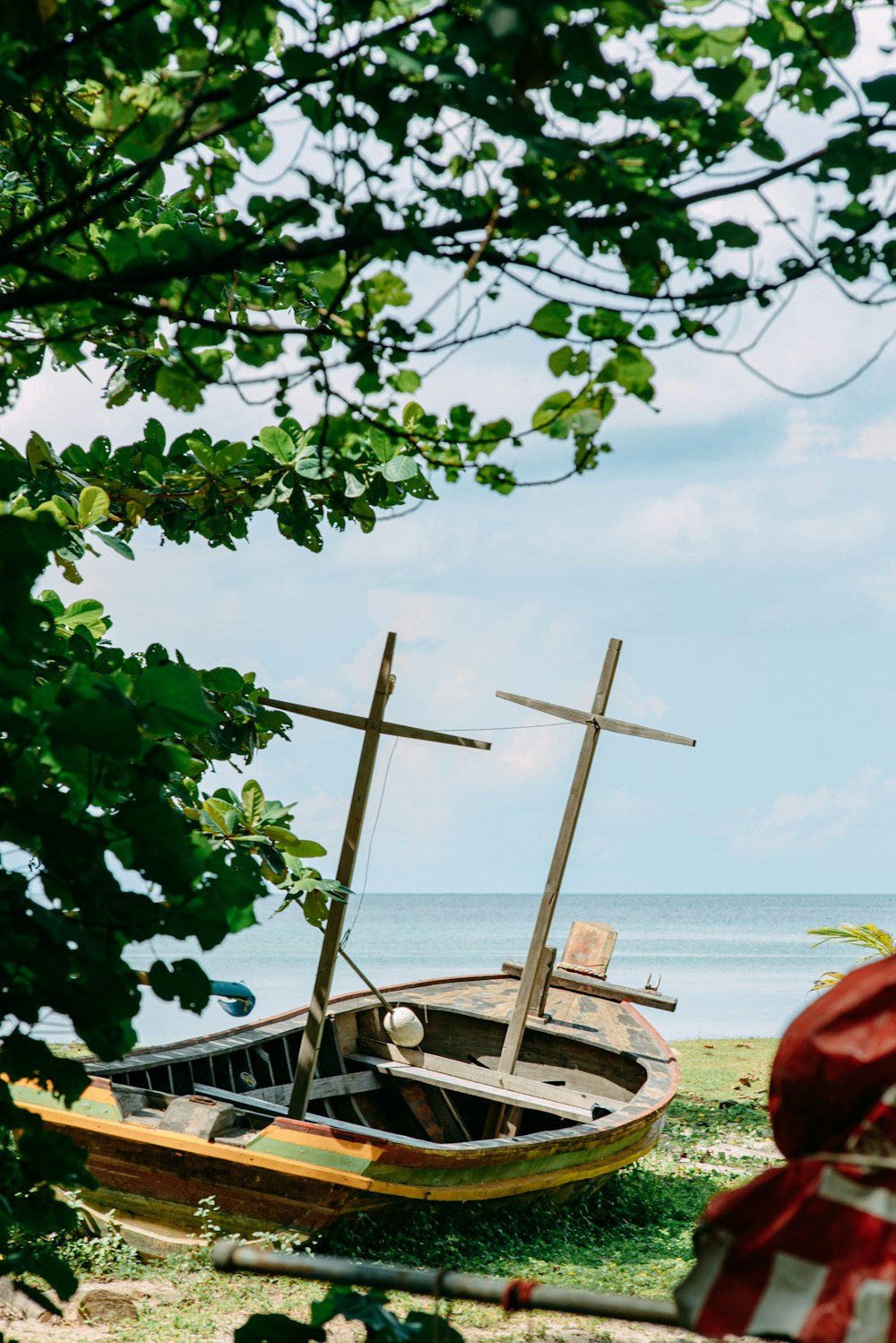 a wooden boat sitting on top of a grass covered field