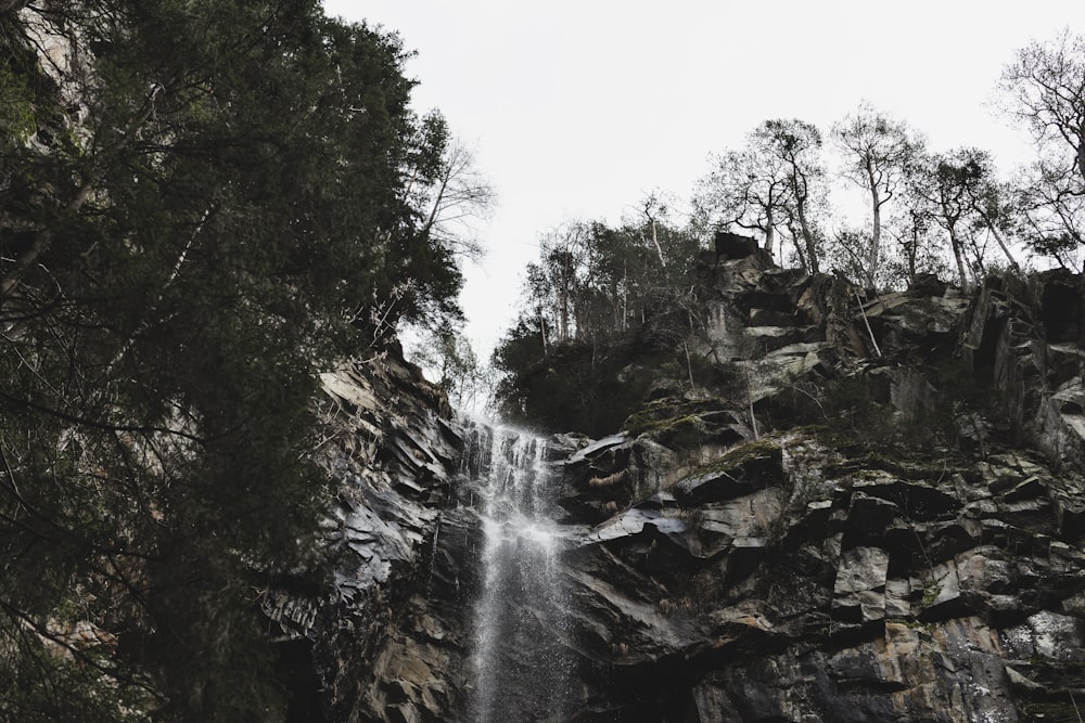 a waterfall is seen from the bottom of a cliff