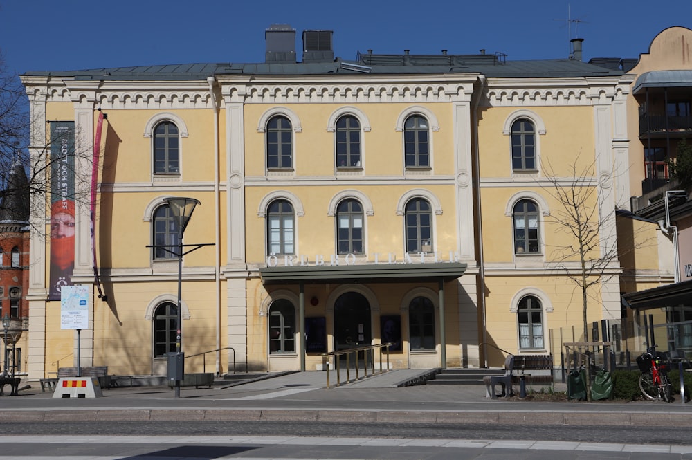 a large yellow building sitting on the side of a road