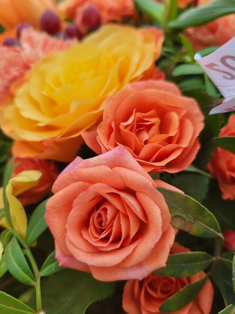 a bouquet of orange and yellow flowers with a price tag