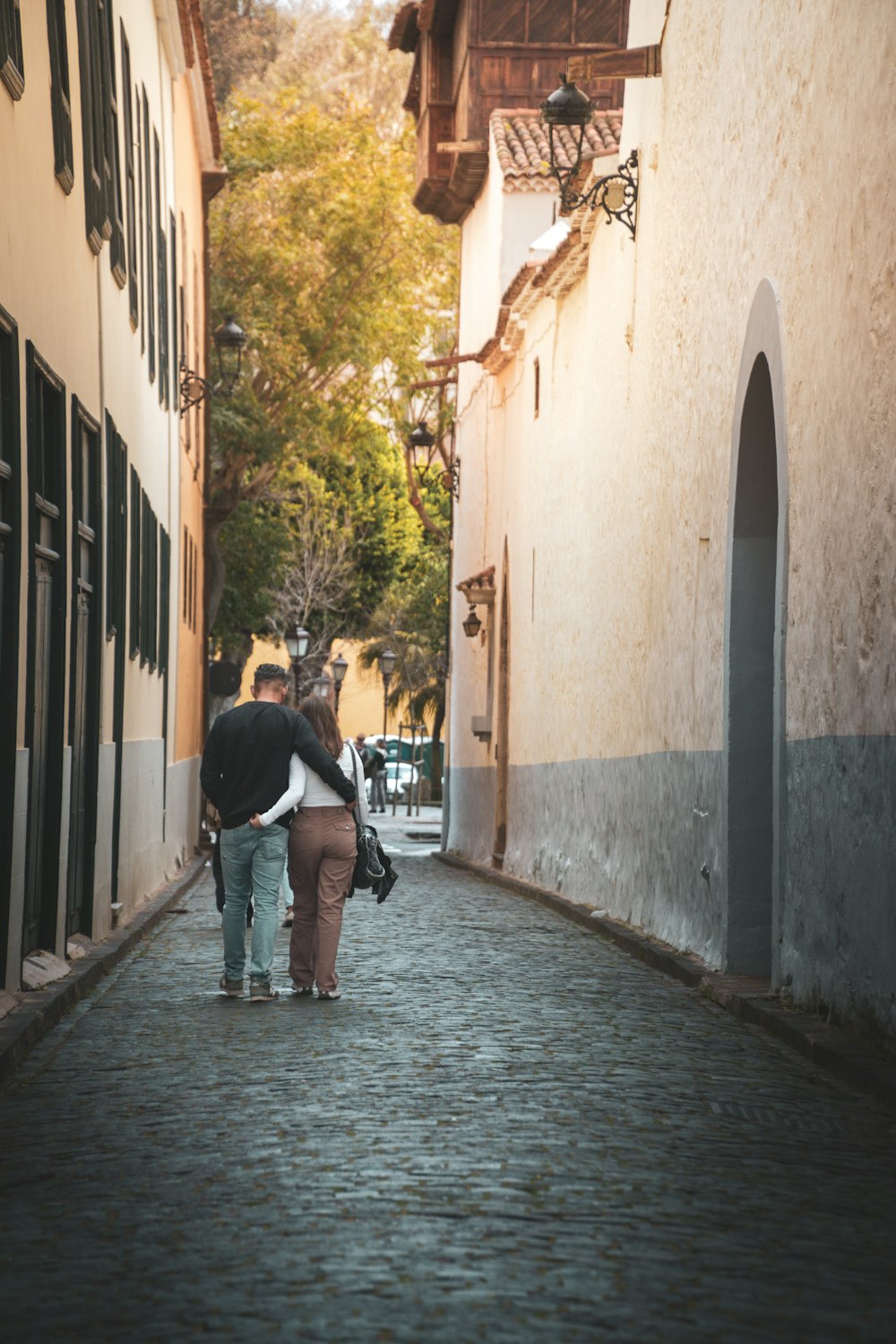 a couple of people walking down a street