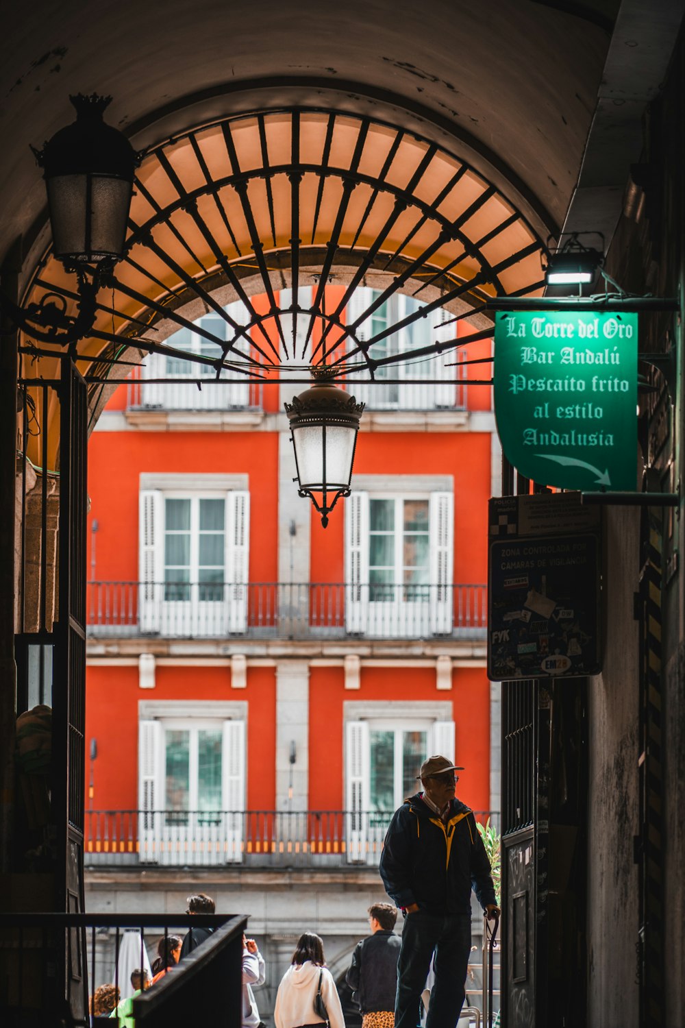 a man walking down a street next to a red building