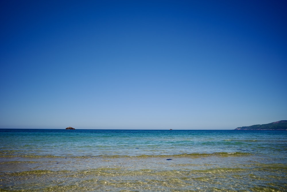 a body of water sitting under a blue sky