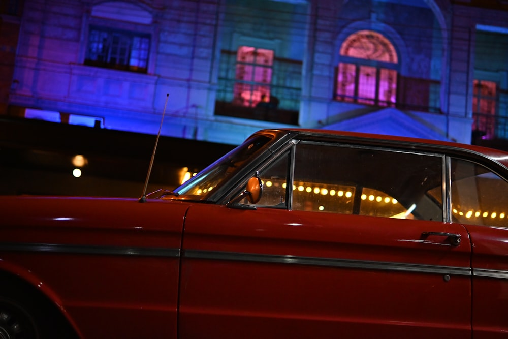 a red car parked in front of a building