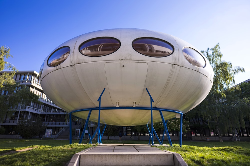 a large white object sitting on top of a lush green field