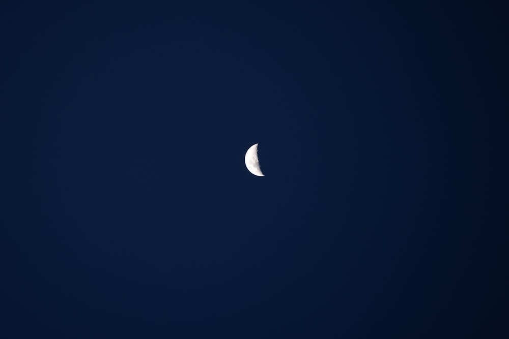 a half moon in a dark blue sky