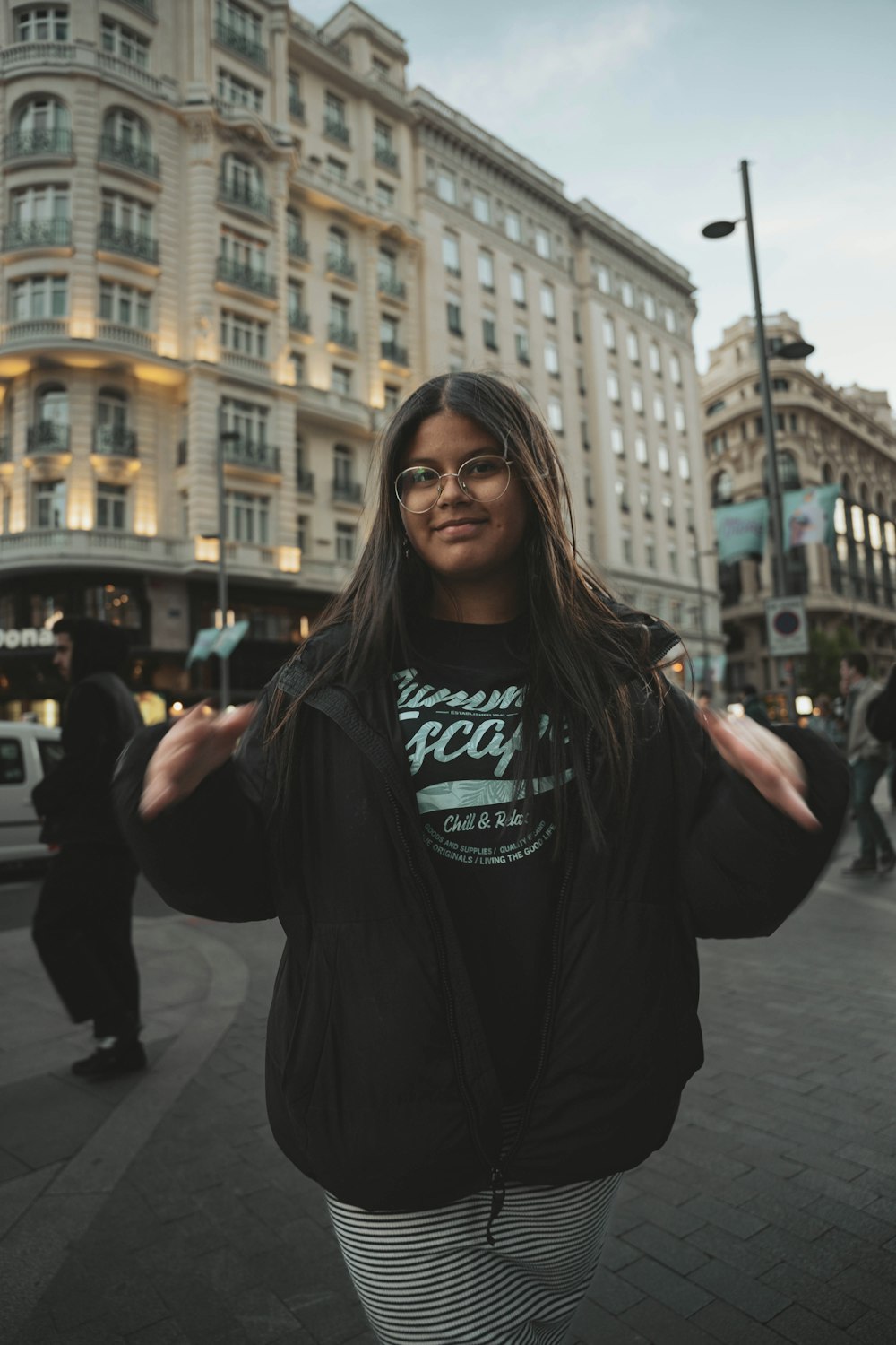 une femme debout devant un grand bâtiment