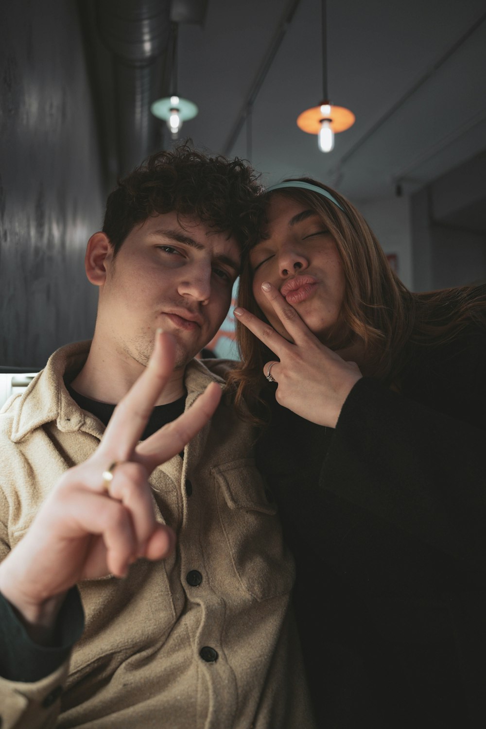 a man and a woman making a peace sign