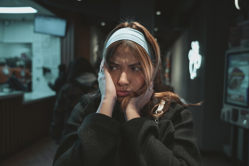 a woman with a headband on talking on a cell phone