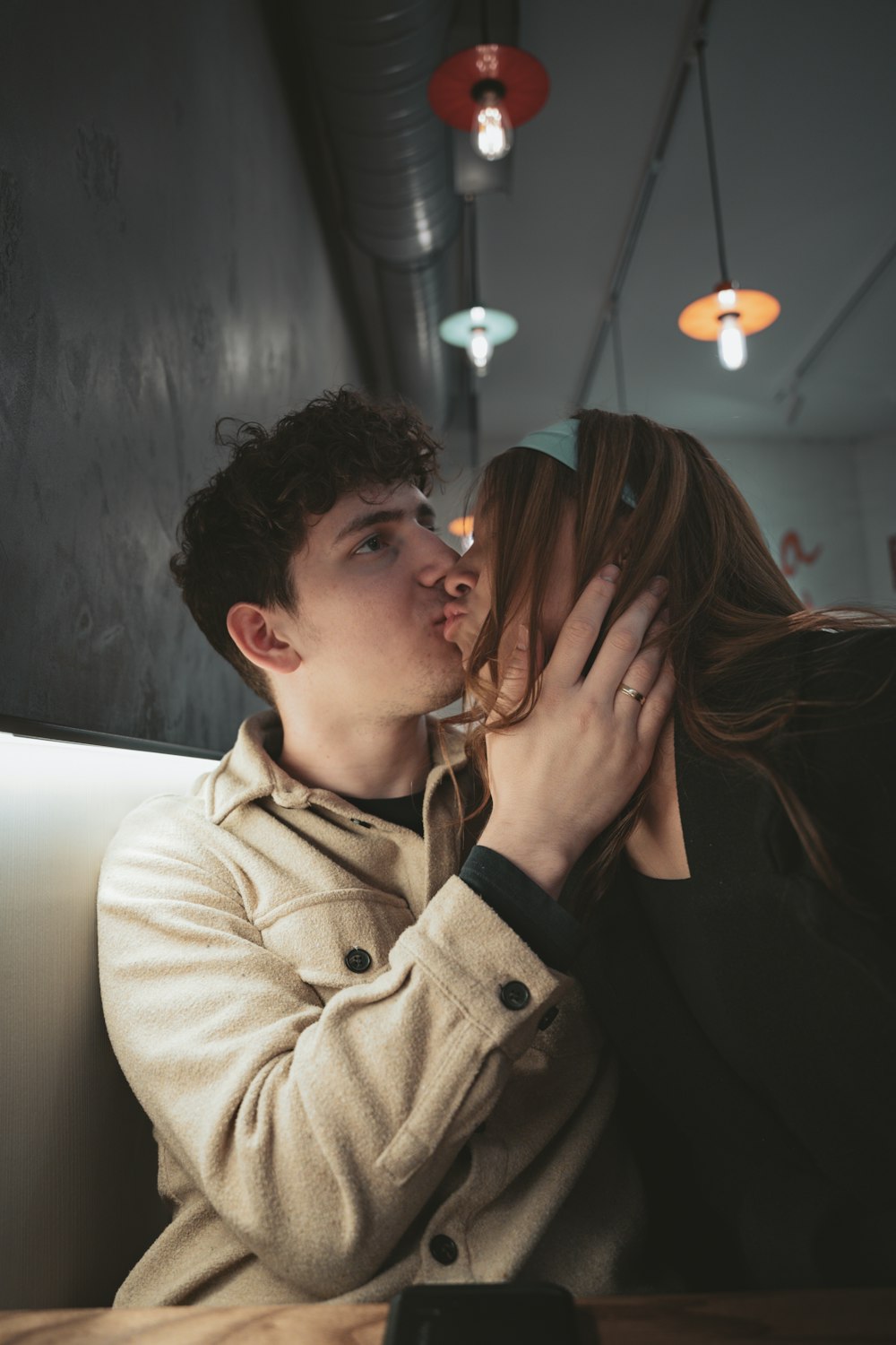 a man and a woman kissing in a restaurant