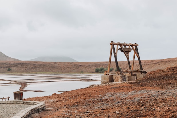 a large wooden structure sitting on top of a dry grass field