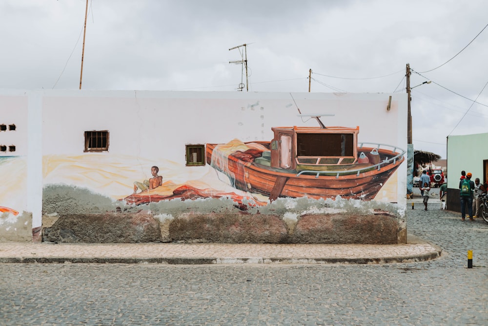 a painting of a boat on the side of a building