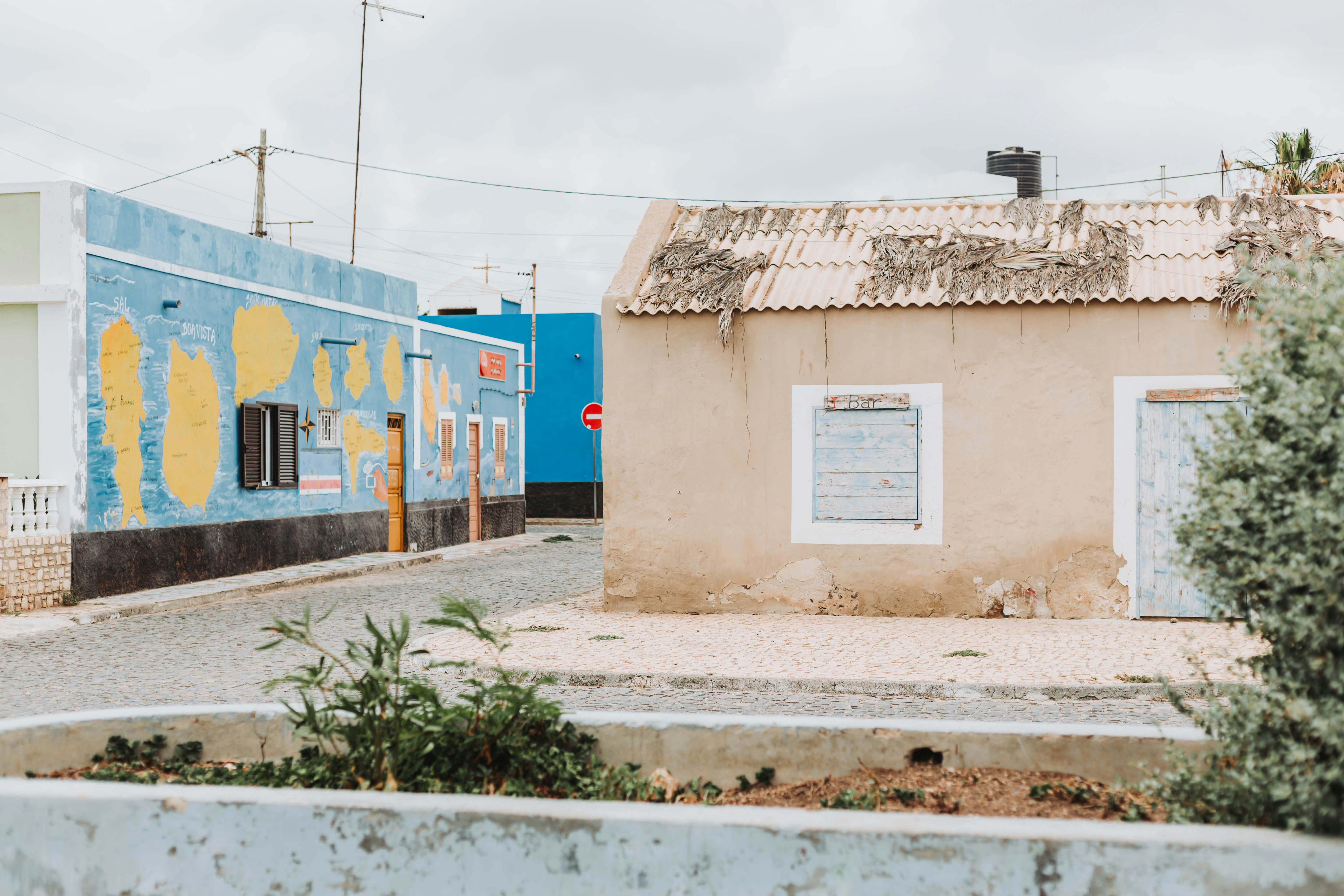 Un pequeño edificio con una puerta azul a un lado
