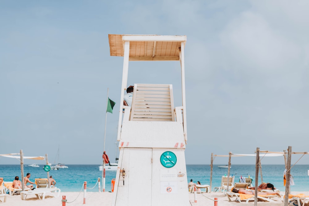 a lifeguard tower on a beach with people in the background