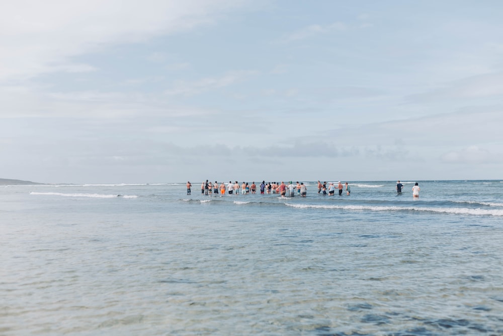 a group of people standing in the ocean