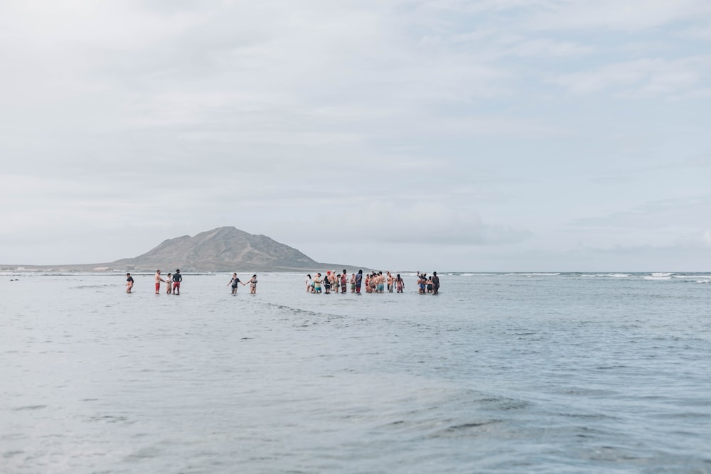 a group of people standing on top of a body of water