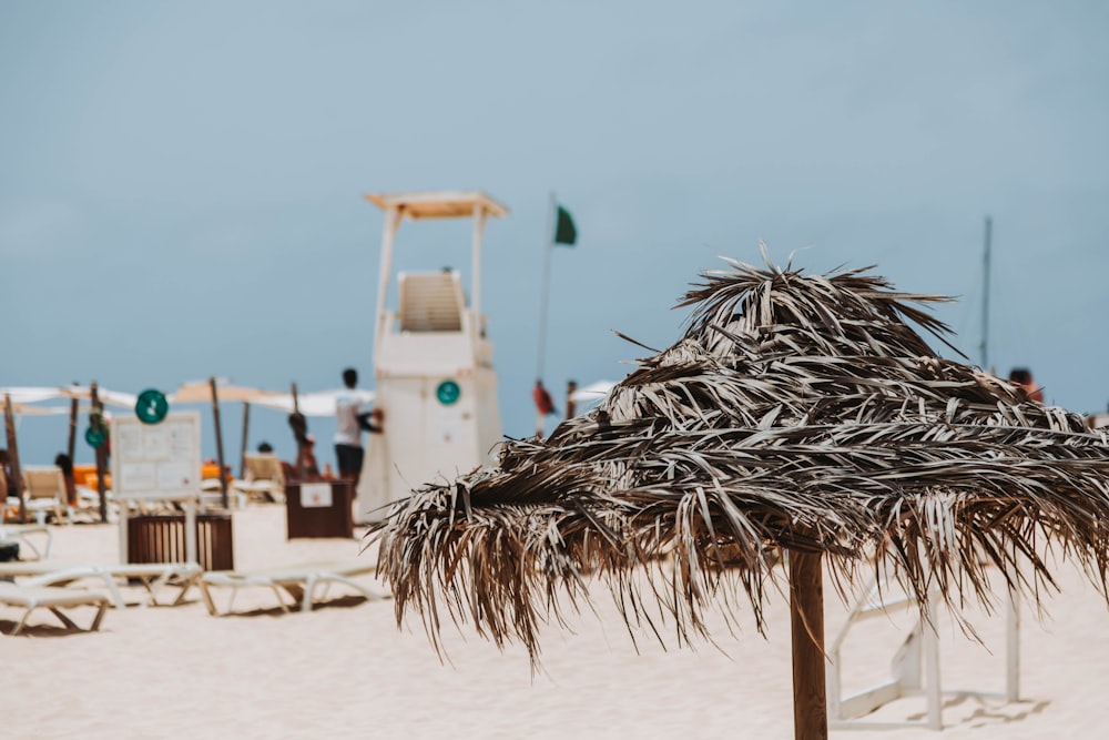 a straw umbrella sitting on top of a sandy beach