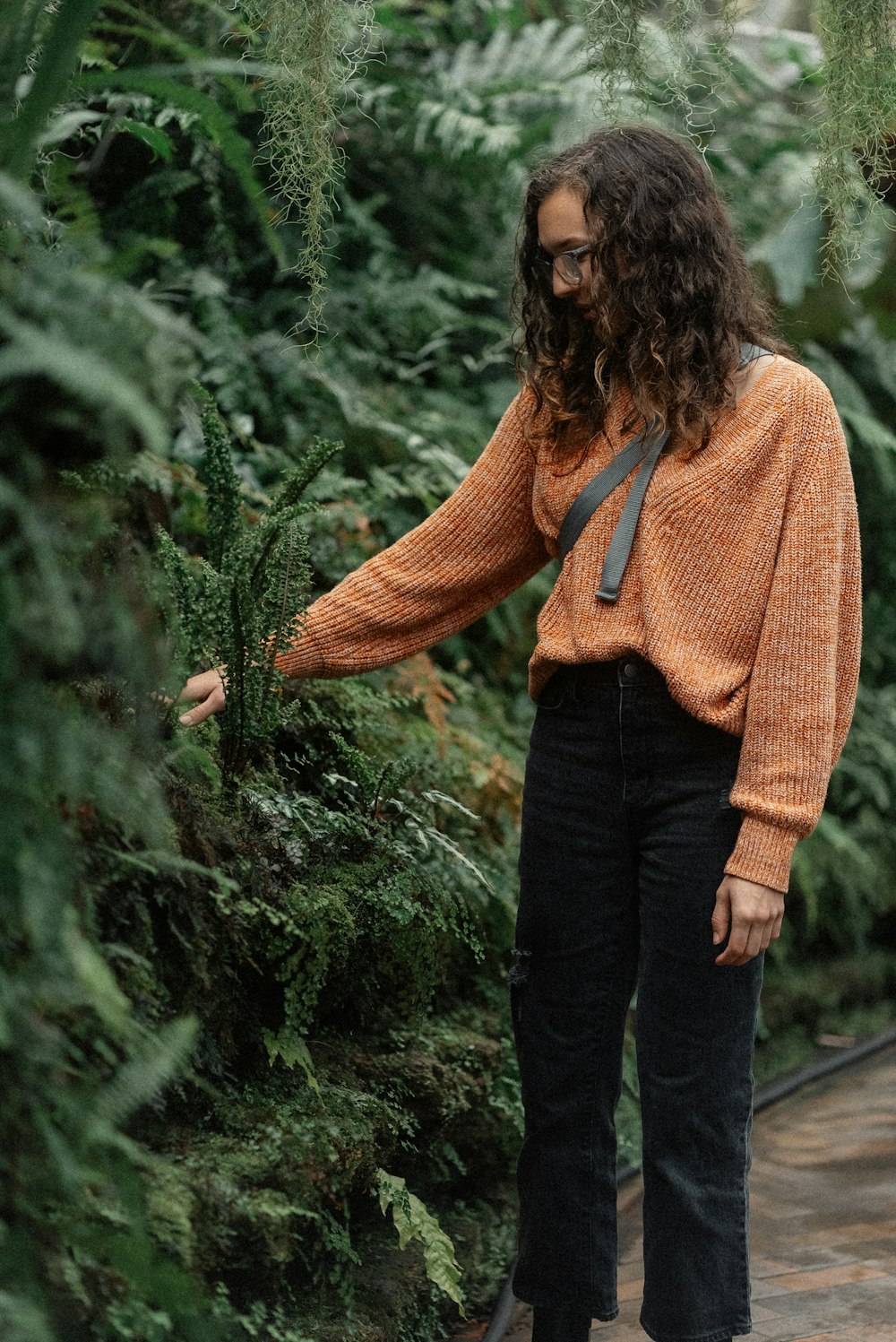 une femme debout devant un bouquet de plantes