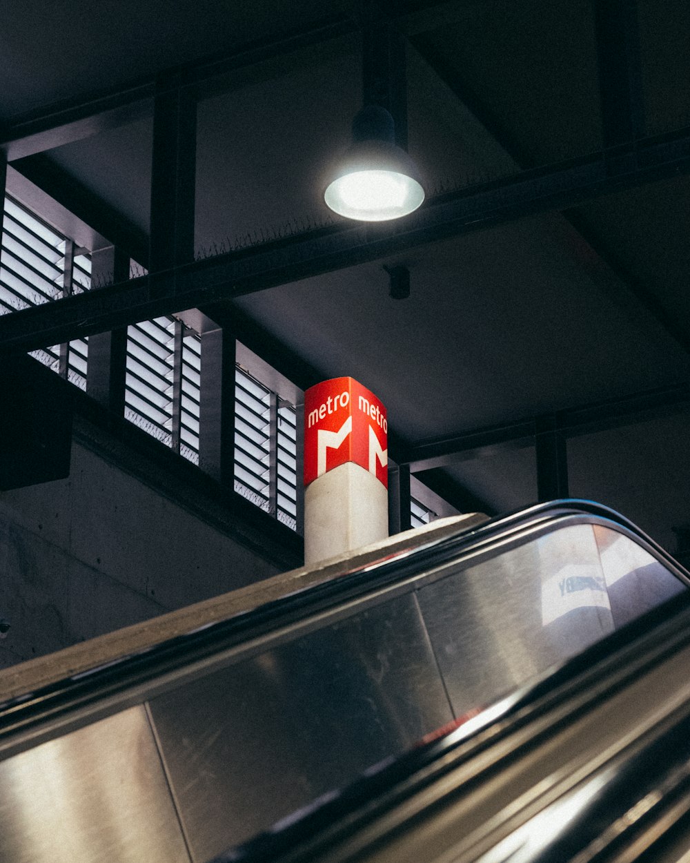 an escalator with a red sign on top of it