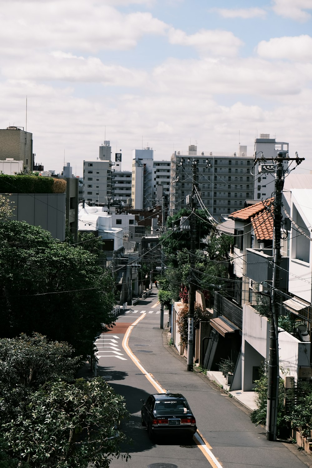 a car driving down a street next to tall buildings