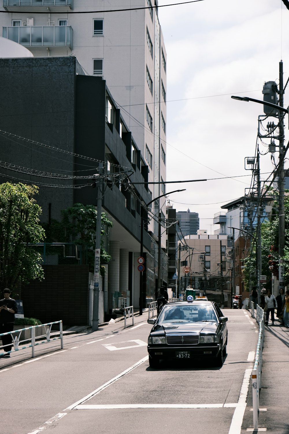 a car driving down a street next to tall buildings