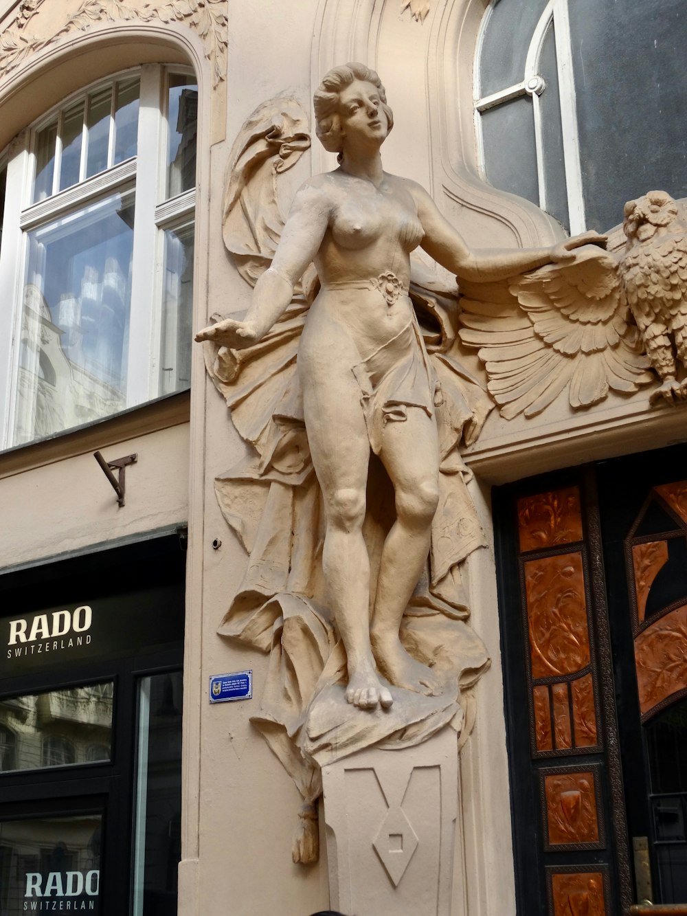 a statue of a naked man on the side of a building