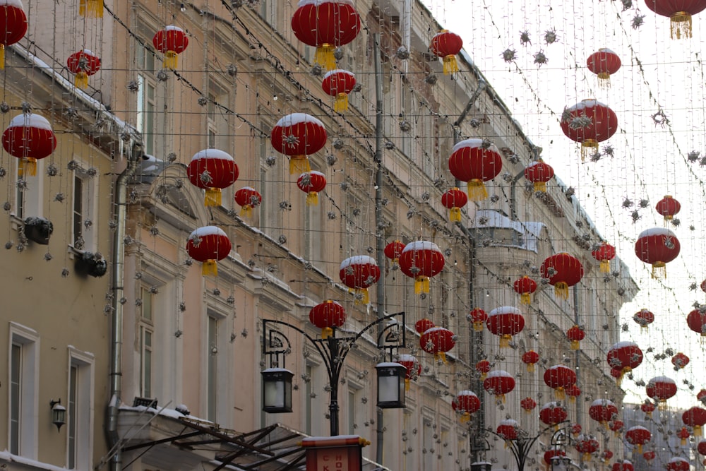 a city street with many red lanterns hanging from the buildings