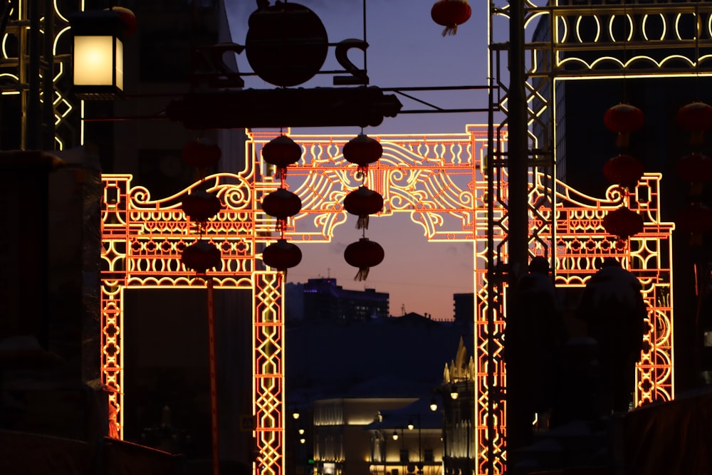 um arco iluminado no meio de uma cidade à noite