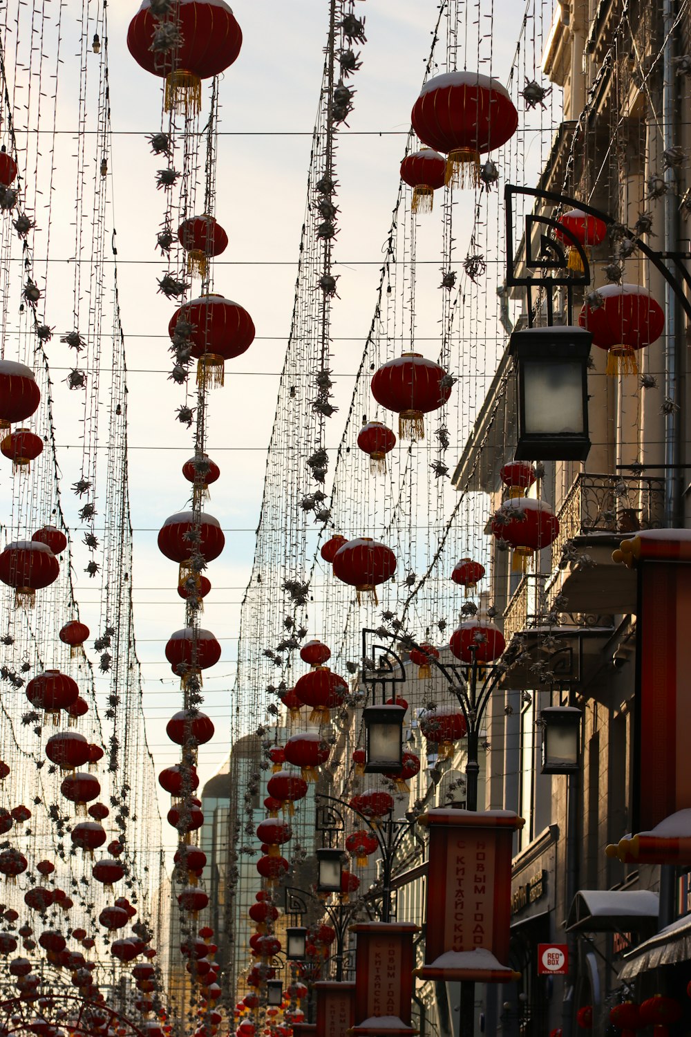 a street with lots of red lanterns hanging from it's sides