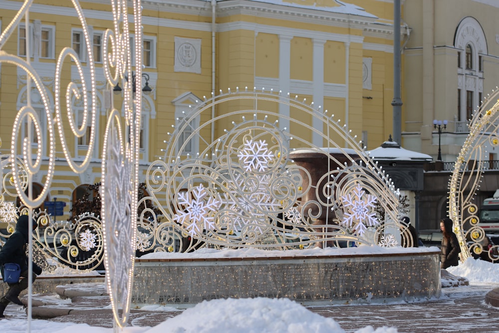 a group of people standing around a snow covered fountain