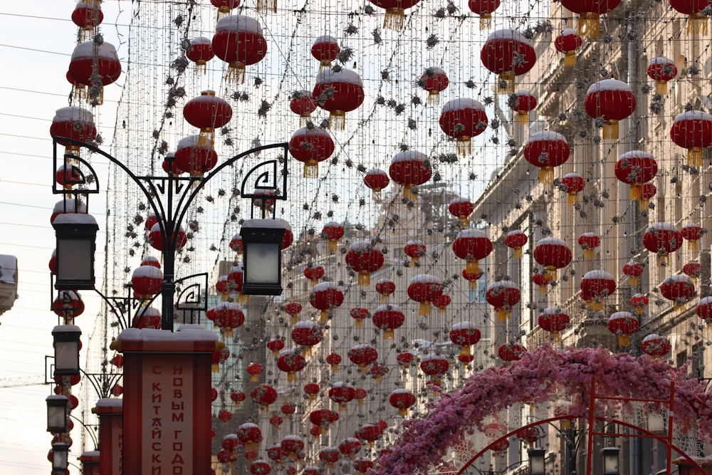 a bunch of red lanterns hanging from the side of a building